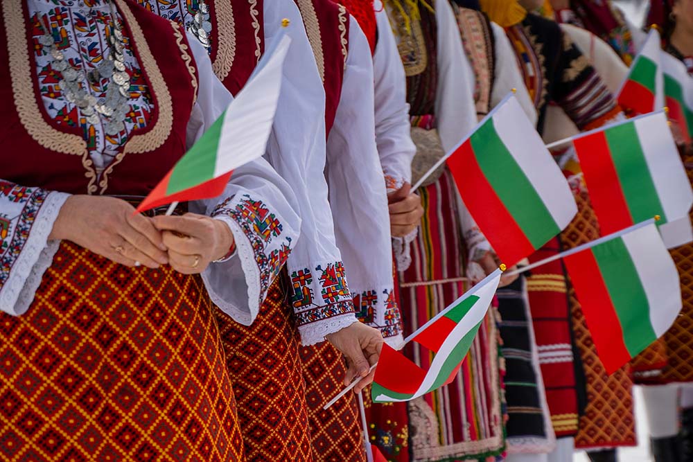Жени държат български знамена.