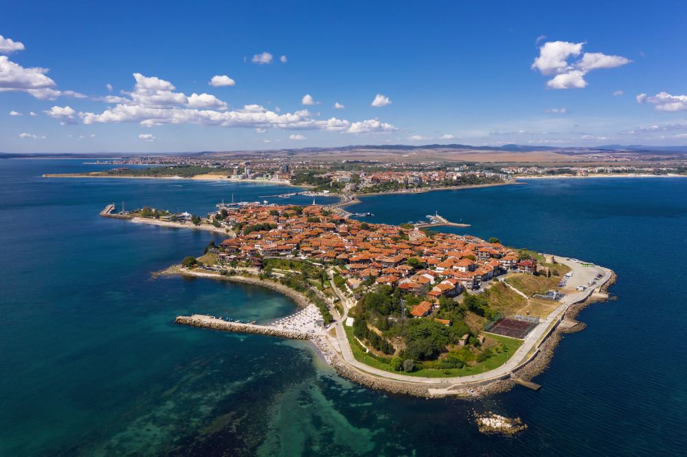 Аерофотография на древния крайморски град-полуостров в България, подчертаваща културния контекст на сделките с недвижими имоти